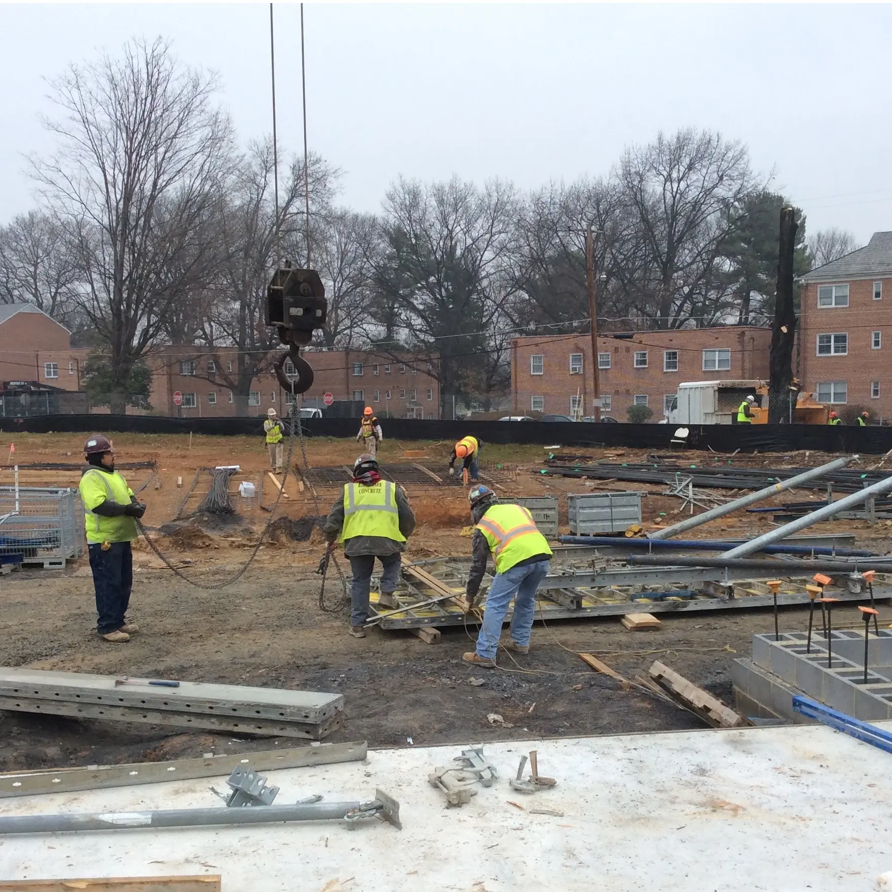 Construction crew working with materials and rigging at a building site