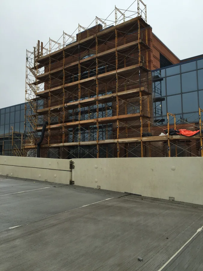 Scaffolding around the exterior of a brick building under construction